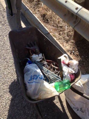 The suspect was caught red-handed with his wheelbarrow containing tools he used to saw off the sign board. 