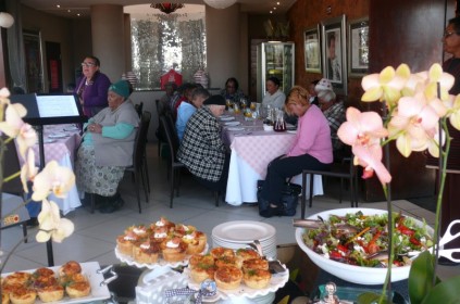 The women say a prayer before they have lunch.
